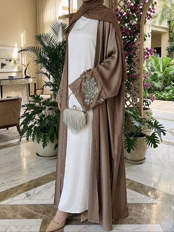 Abaya-cardigan une pièce en satin, ouverte sur le devant, ornée de broderies ajourées et de perles, avec broderies papillon en relief (style kimono) ; vendue sans sous-robe, ceinture ni foulard.